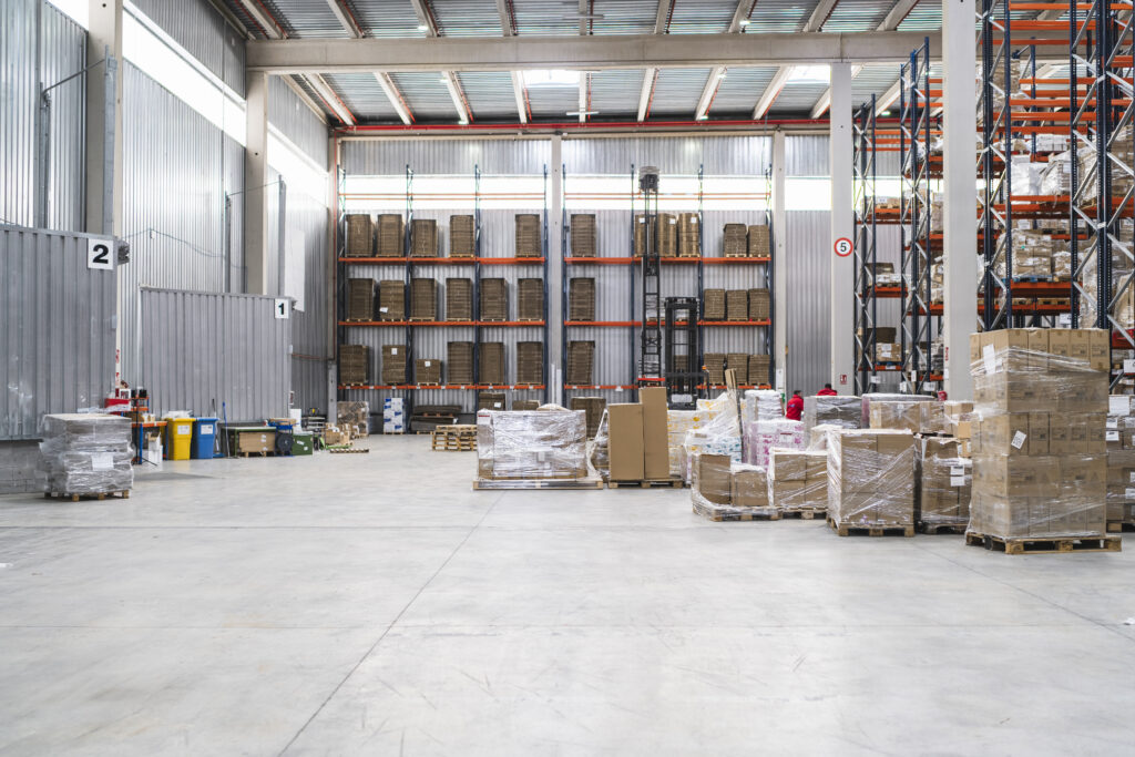 Le scatole di cartone impilate sui pallet, in attesa di essere spedite in un ampio magazzino di distribuzione, mettono in evidenza l'efficienza delle operazioni logistiche